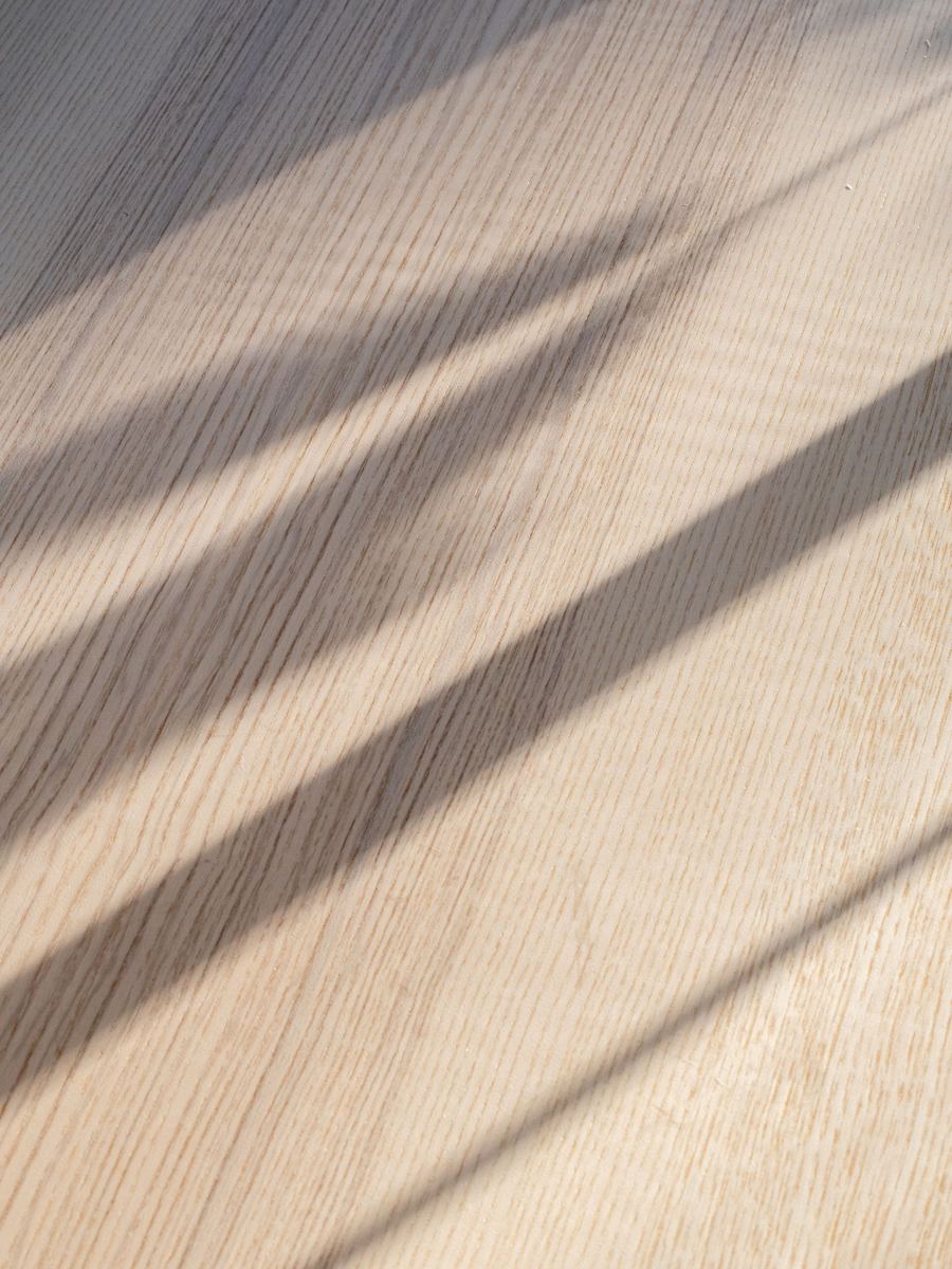 Heller Holzboden mit Schattenwurf durch ein Fenster